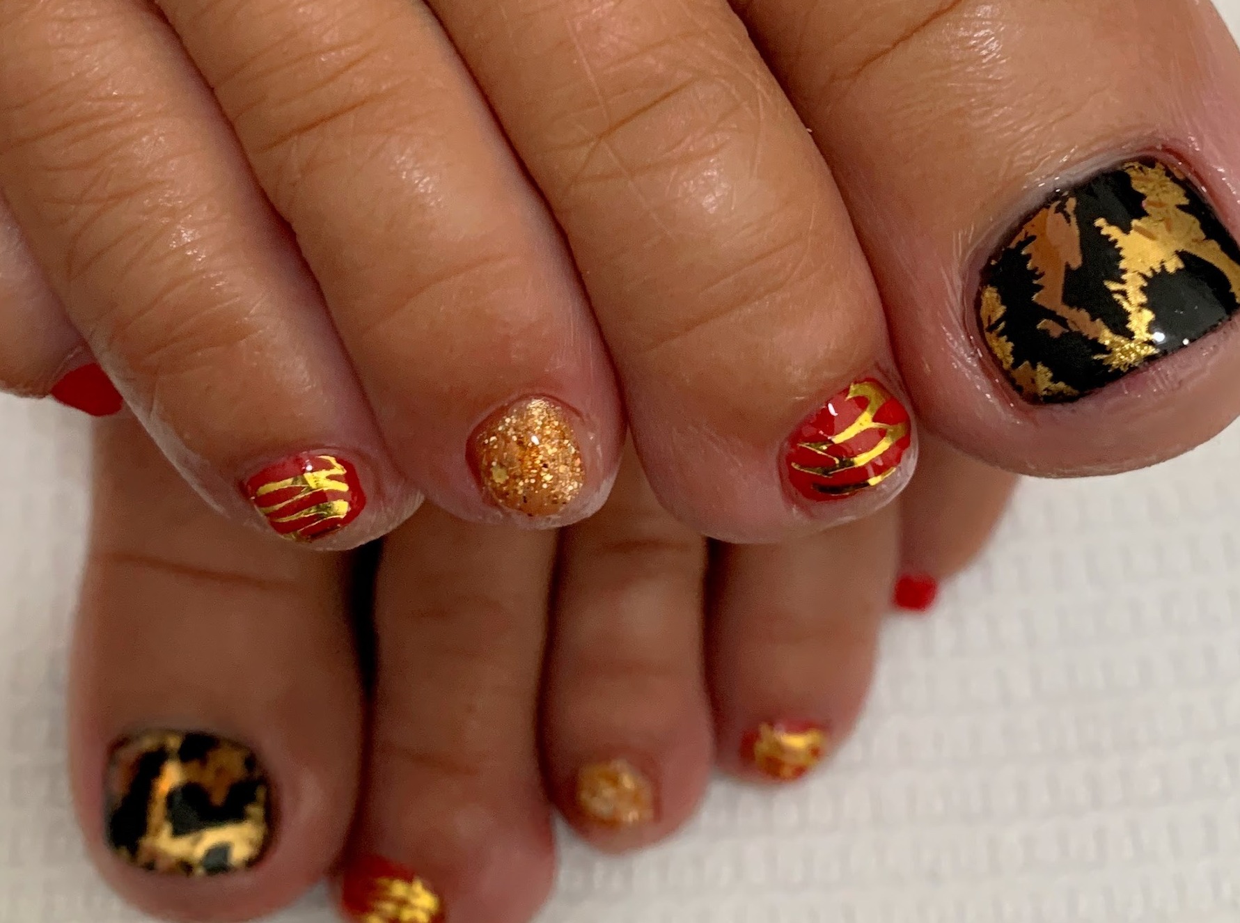 Teennagels gelakt in goud en zwart